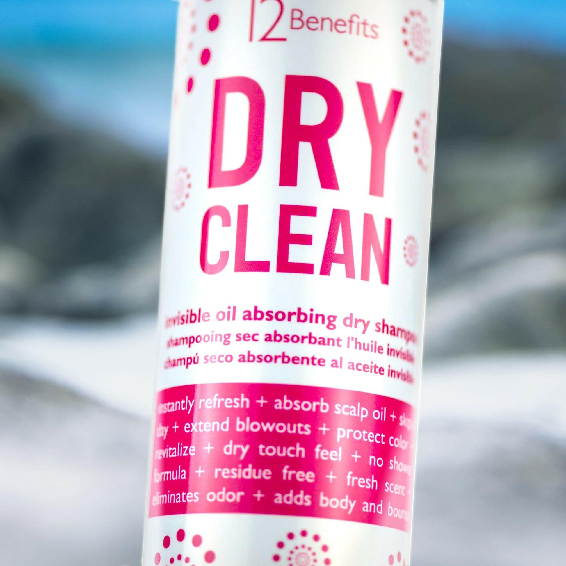 A can of 12 Benefits Dry Clean dry shampoo with a pink label decorative patterns and benefits liste